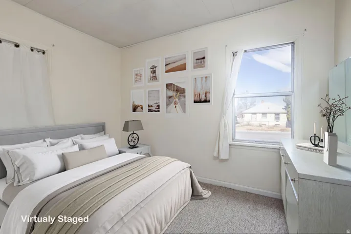 Bedroom with light colored carpet and baseboards