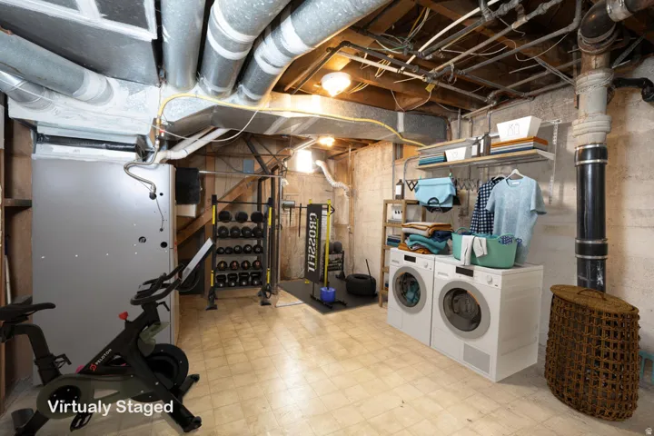 Unfinished basement featuring tile patterned floors and washer and clothes dryer