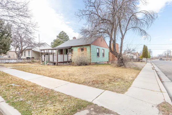 View of front of house with a chimney and a front yard