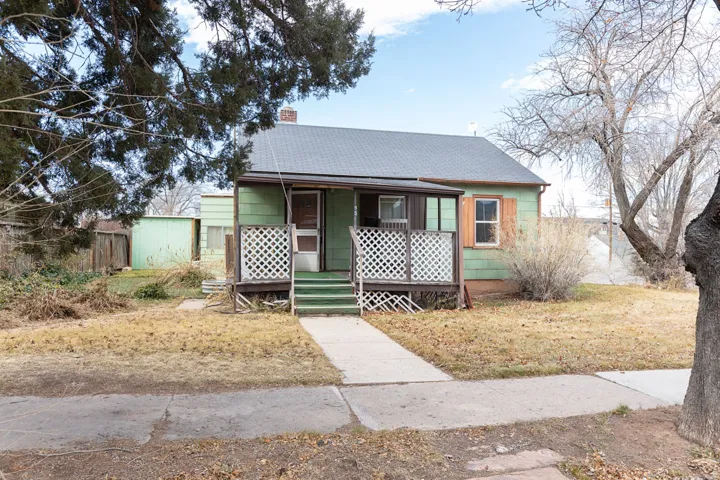 Bungalow featuring roof with shingles, a porch, a chimney, and a front yard