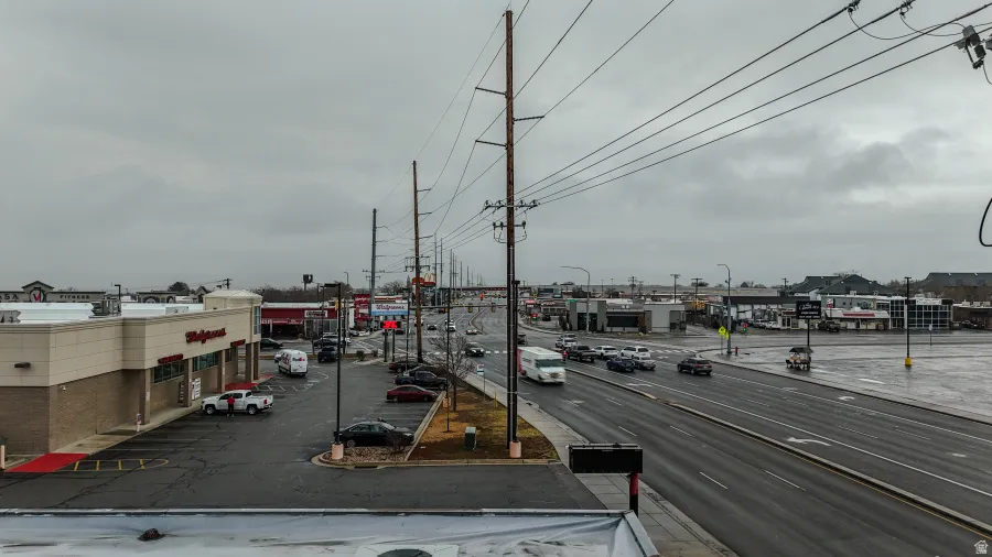 View of asphalt street featuring street lights, sidewalks, and curbs