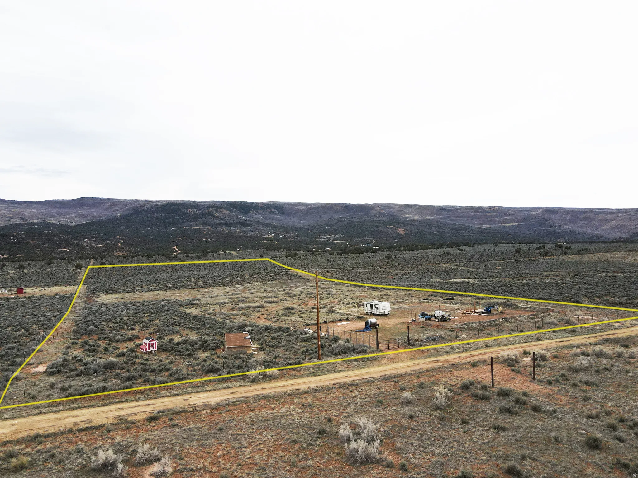 Aerial view of sparsely populated area featuring property parcel outlined and mountains