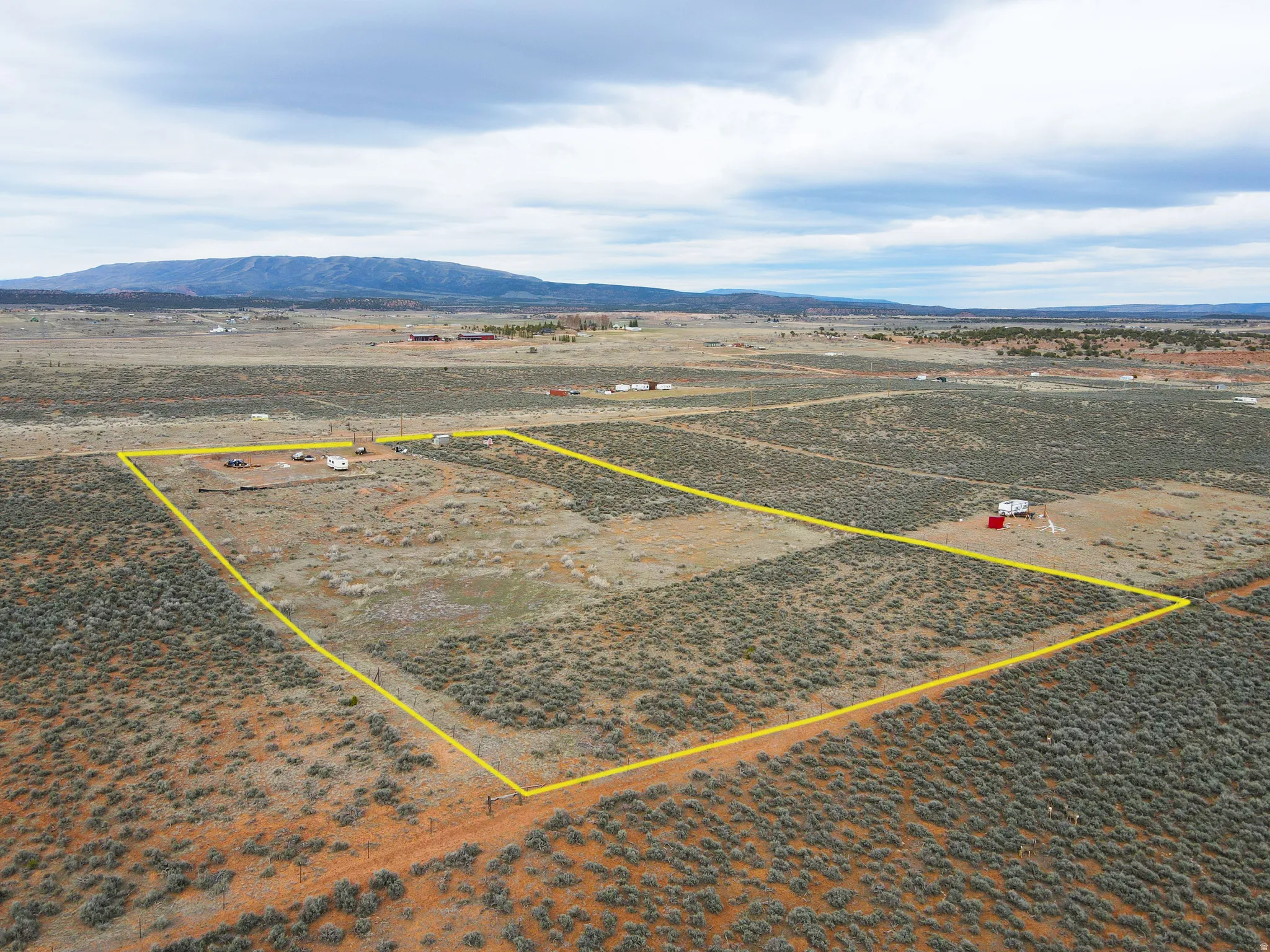 Overview of rural landscape with a mountain backdrop and property parcel outlined
