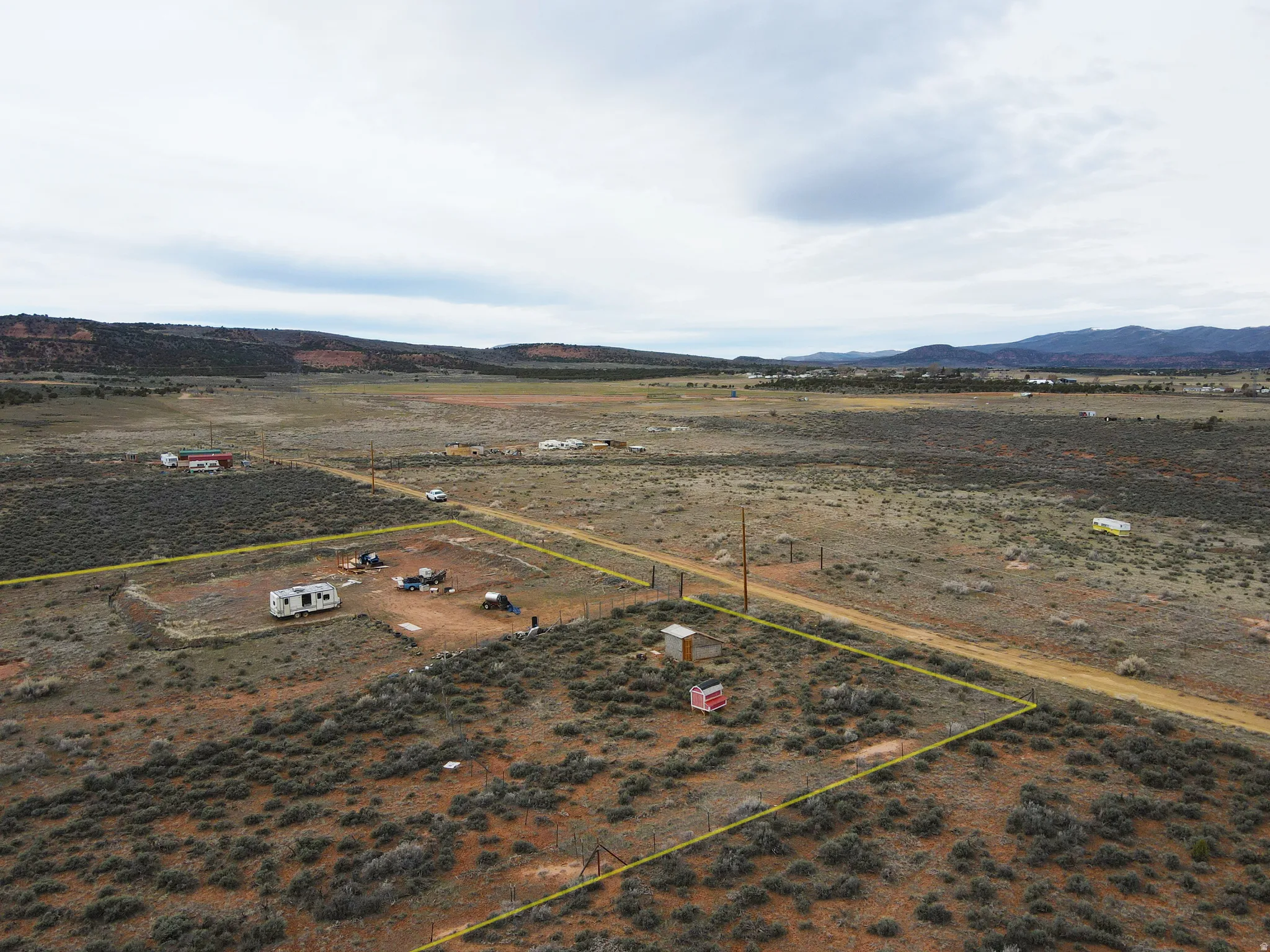 Aerial view of sparsely populated area with mountains and property parcel outlined