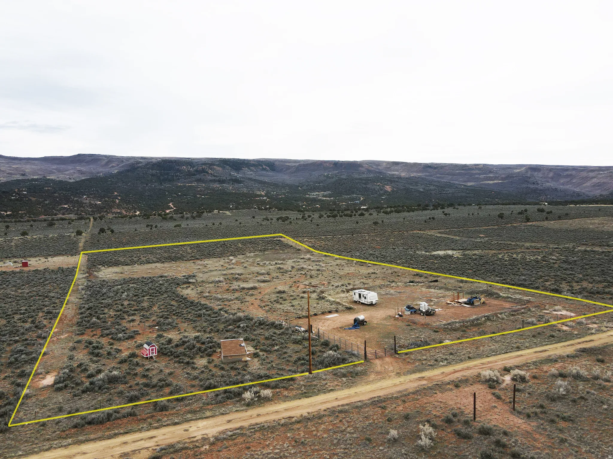 Overview of rural landscape featuring property boundaries highlighted and a mountain backdrop