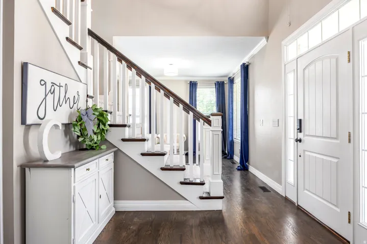 Foyer entrance featuring ornamental molding and dark wood finished floors