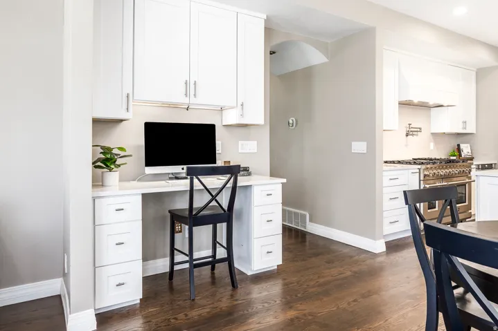 Home office with dark wood-type flooring and baseboards