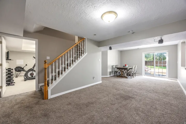 Carpeted living room featuring baseboards and a textured ceiling