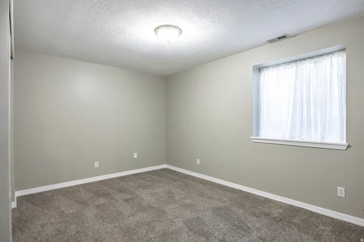Empty room featuring carpet floors and a textured ceiling