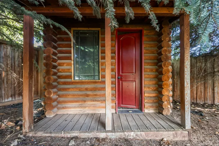 Doorway to property with log siding and a porch