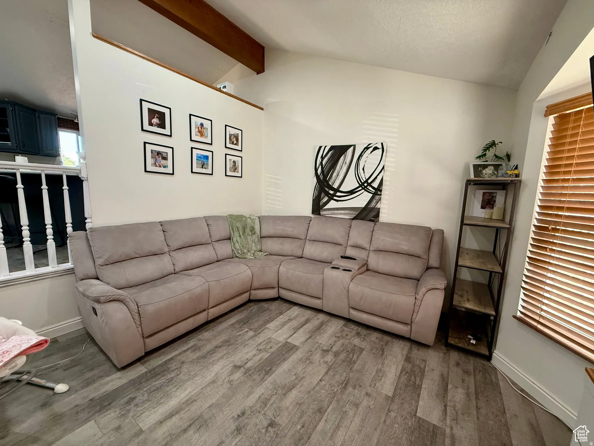 Living room with beamed ceiling and wood finished floors