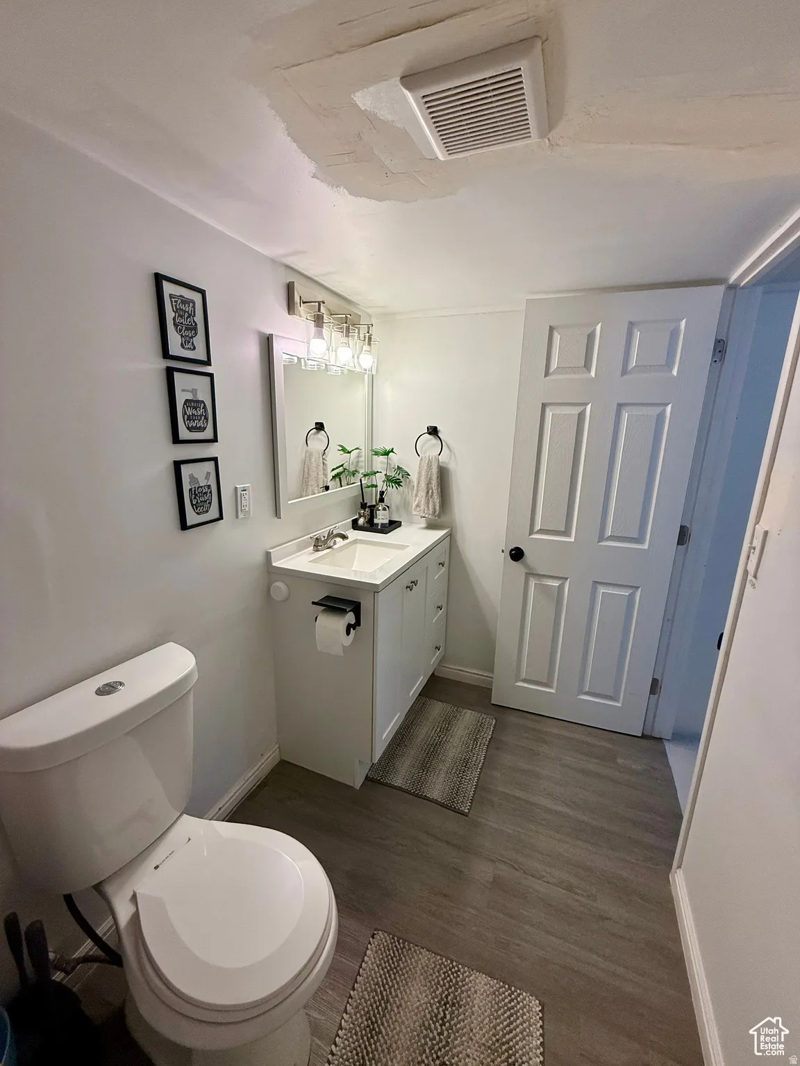 Bathroom featuring cooling unit, vanity, and dark wood-type flooring