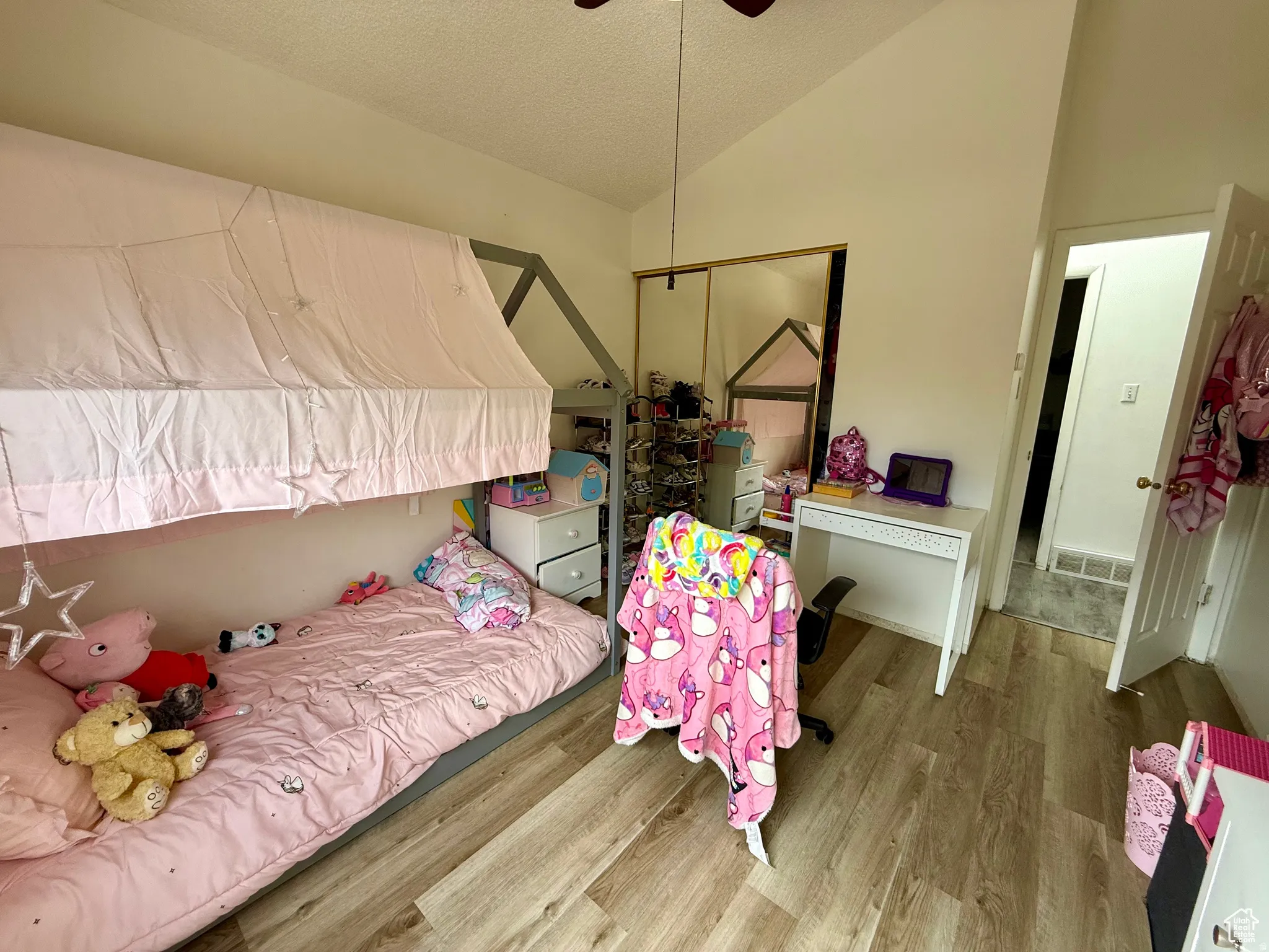 Bedroom featuring wood finished floors, a closet, and a ceiling fan