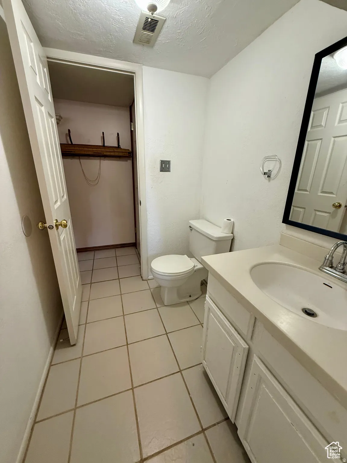 Bathroom featuring vanity, a textured ceiling, and light tile patterned floors