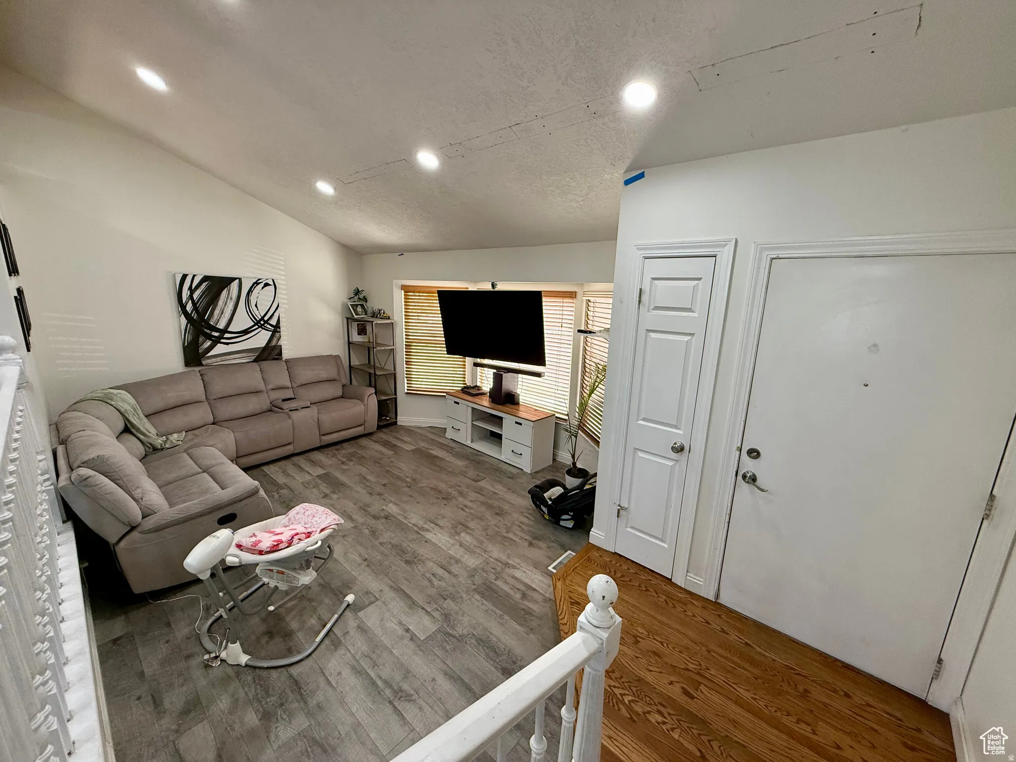 Living room with lofted ceiling, wood finished floors, and recessed lighting