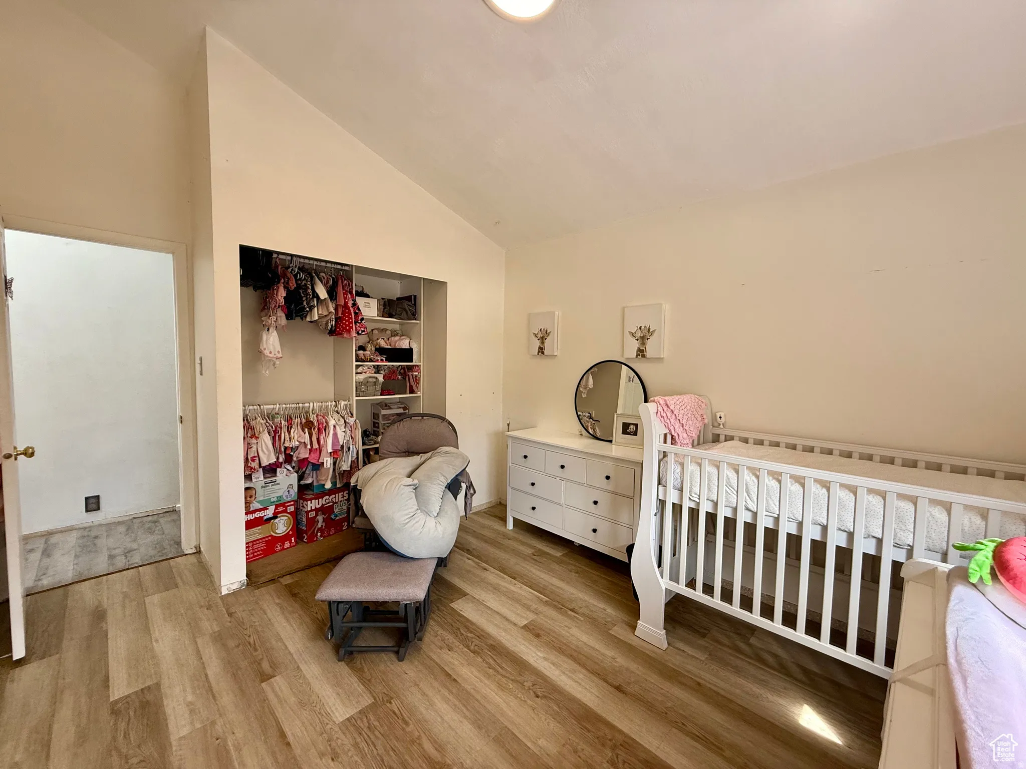Bedroom with lofted ceiling, light wood-style flooring, and a closet