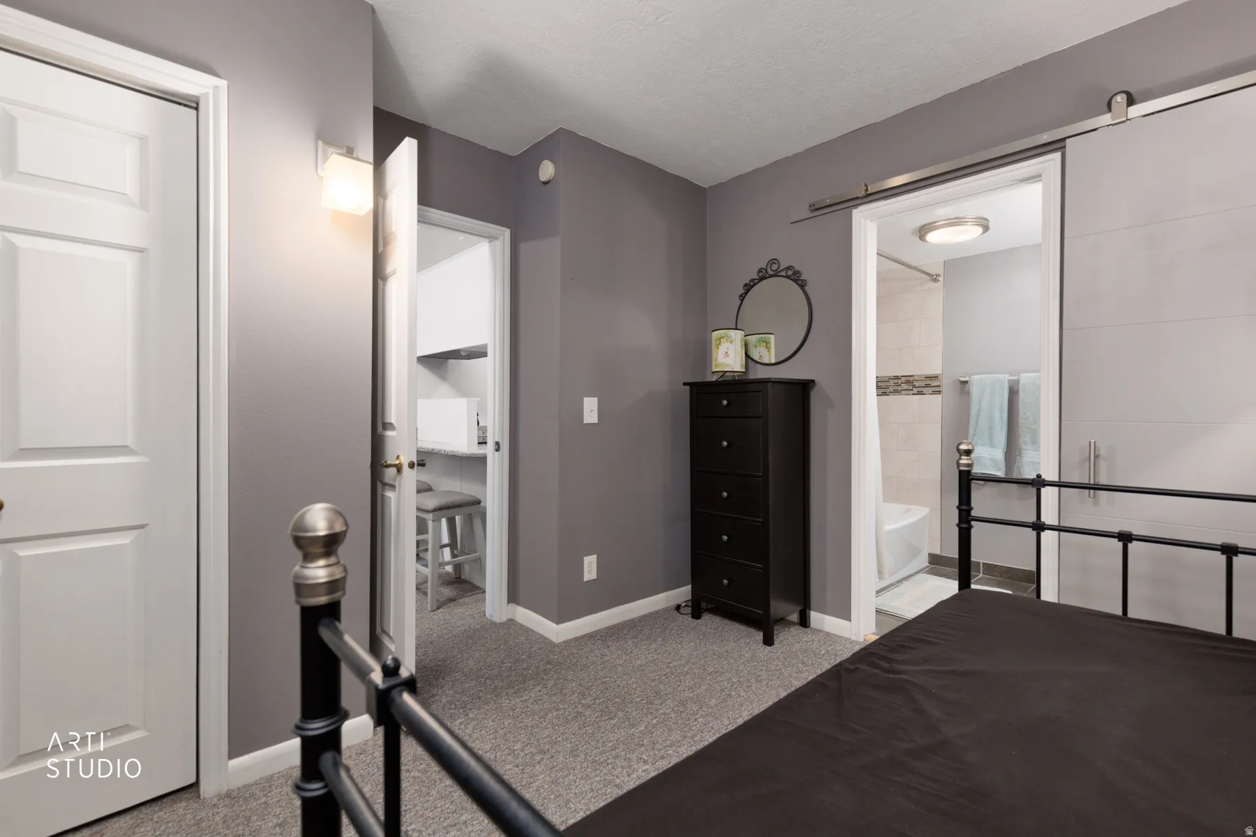 Bedroom featuring light carpet and ensuite bath