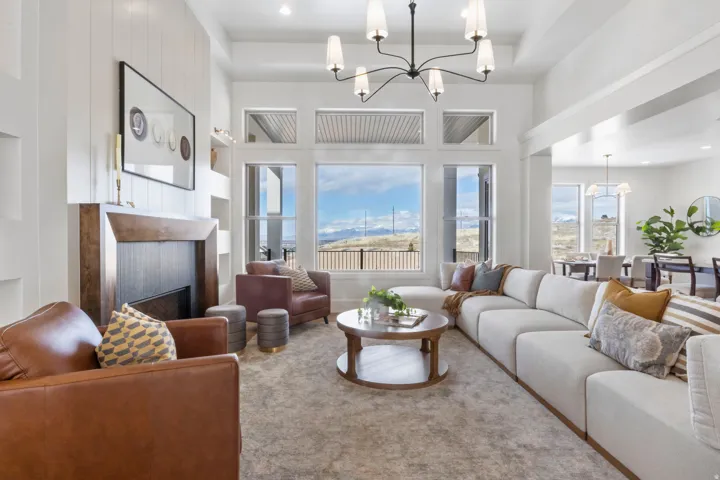 Carpeted living room with a chandelier, a fireplace, built in features, and a high ceiling
