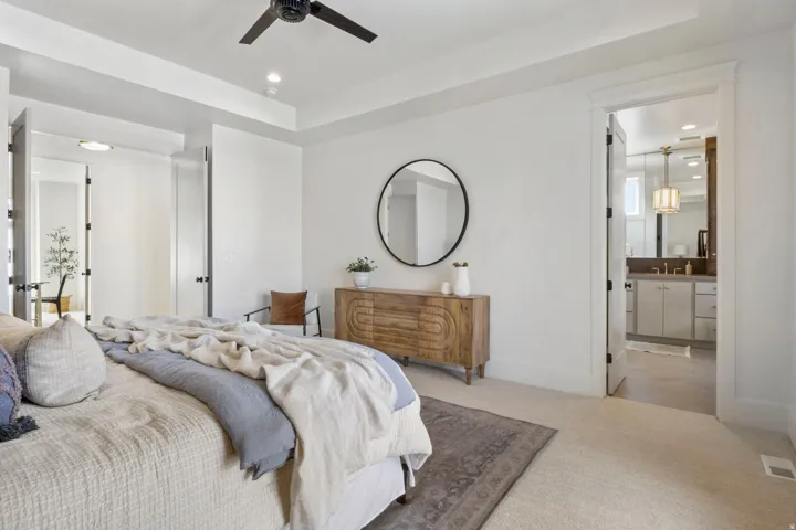 Bedroom featuring connected bathroom, recessed lighting, a raised ceiling, carpet floors, and a ceiling fan