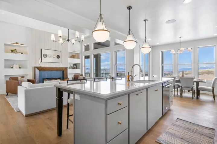 Kitchen with a chandelier, a kitchen breakfast bar, built in features, light wood-style floors, and a fireplace