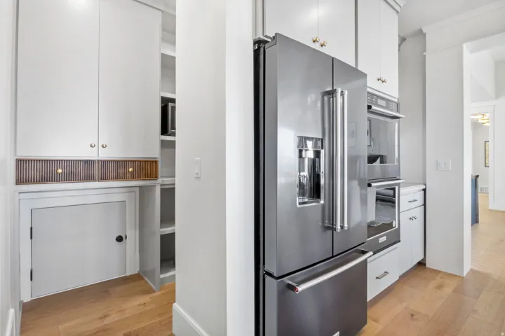 Kitchen with stainless steel appliances, light wood finished floors, and white cabinetry