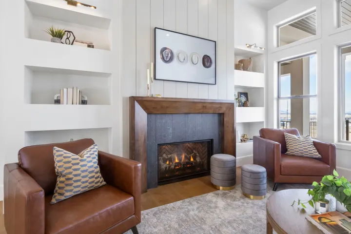 Living room featuring built in features, wood finished floors, and a lit fireplace