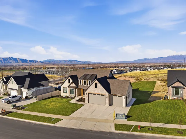View of front of home featuring a residential view, driveway, and a mountain view