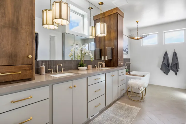 Full bathroom with double vanity, decorative backsplash, a soaking tub, and parquet flooring