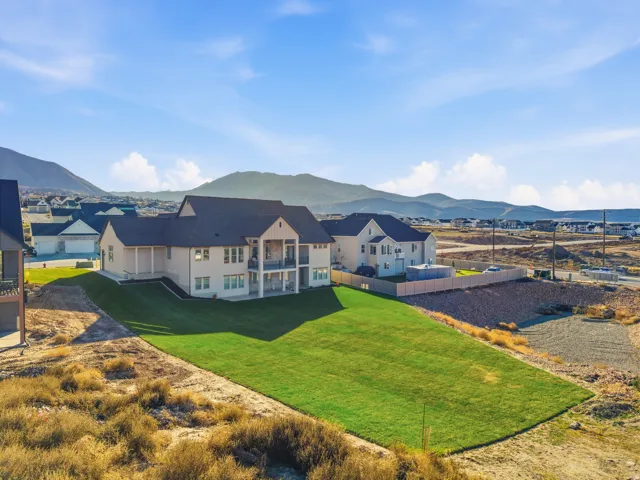 Rear view of property featuring a mountain view, a patio, a residential view, and a balcony