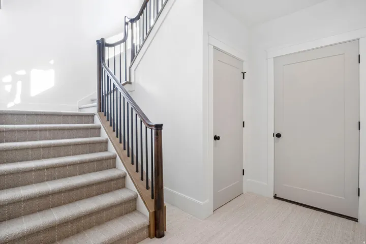 Staircase featuring baseboards and carpet