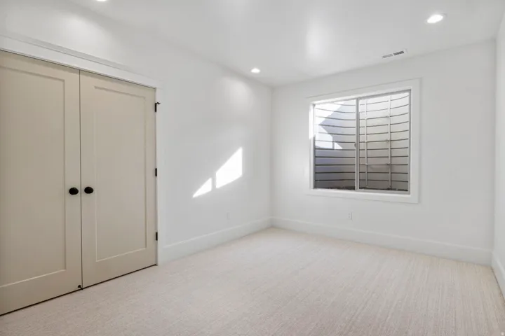 Unfurnished bedroom featuring light colored carpet, a closet, and recessed lighting