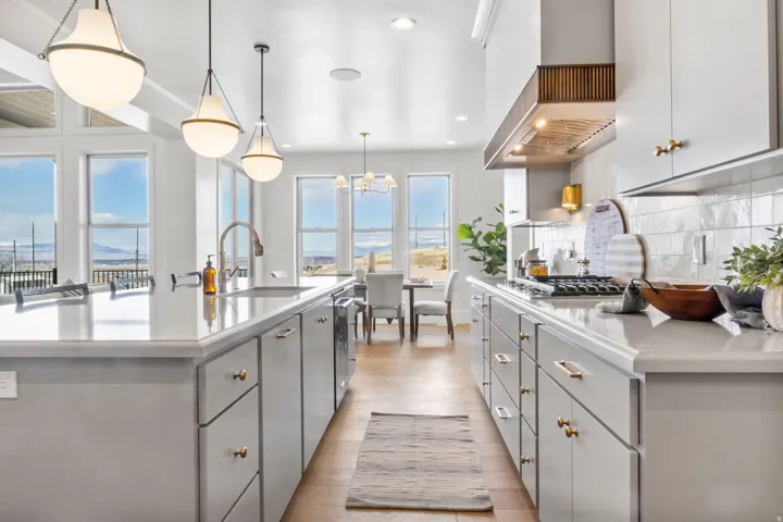 Kitchen with gray cabinets, light wood finished floors, open shelves, a spacious island, and a chandelier