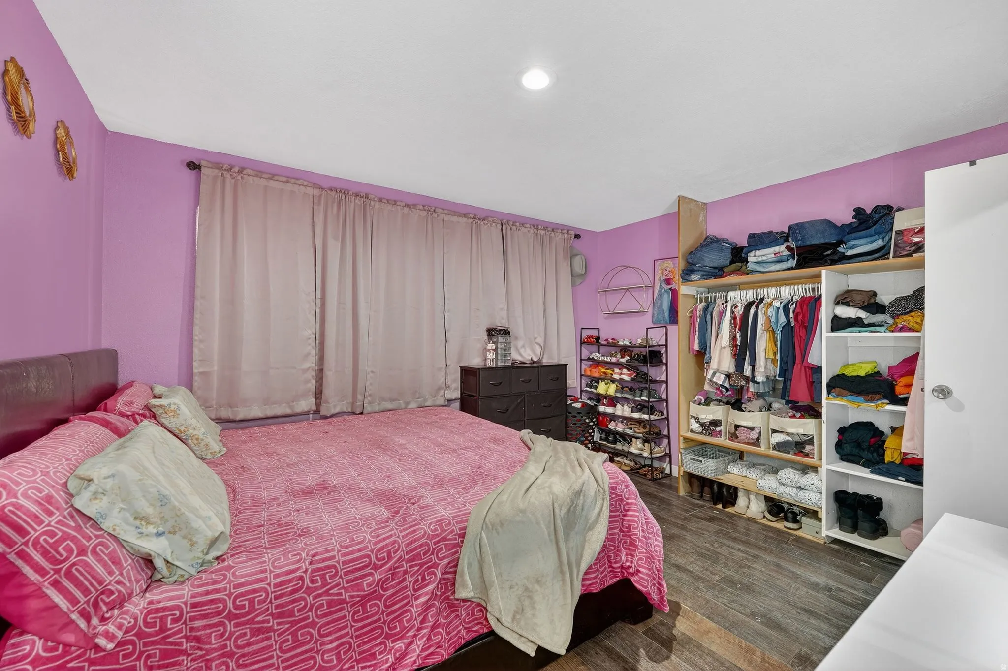Bedroom with dark wood finished floors and a closet