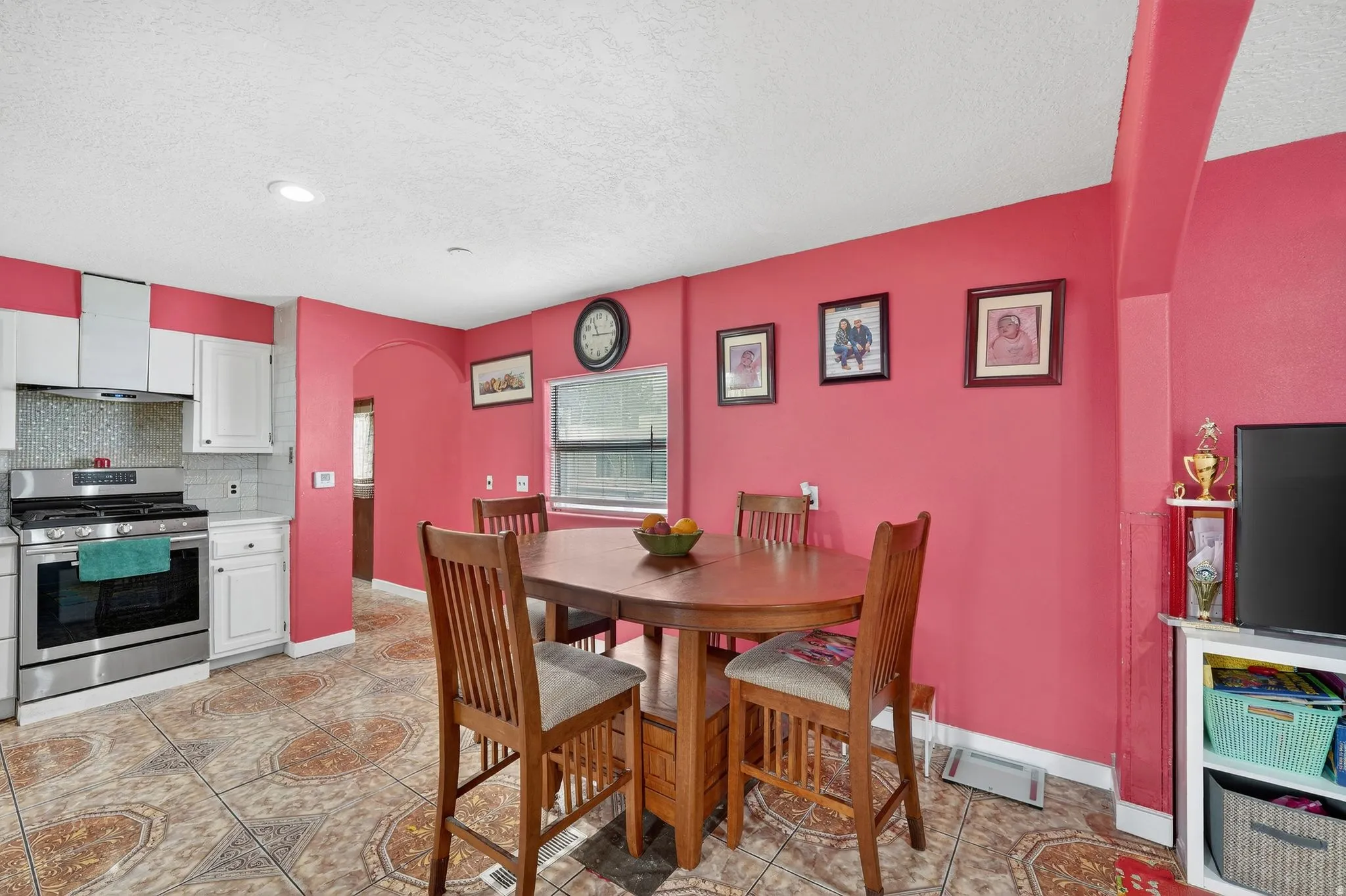 Dining room featuring arched walkways, a textured ceiling, and light tile patterned flooring