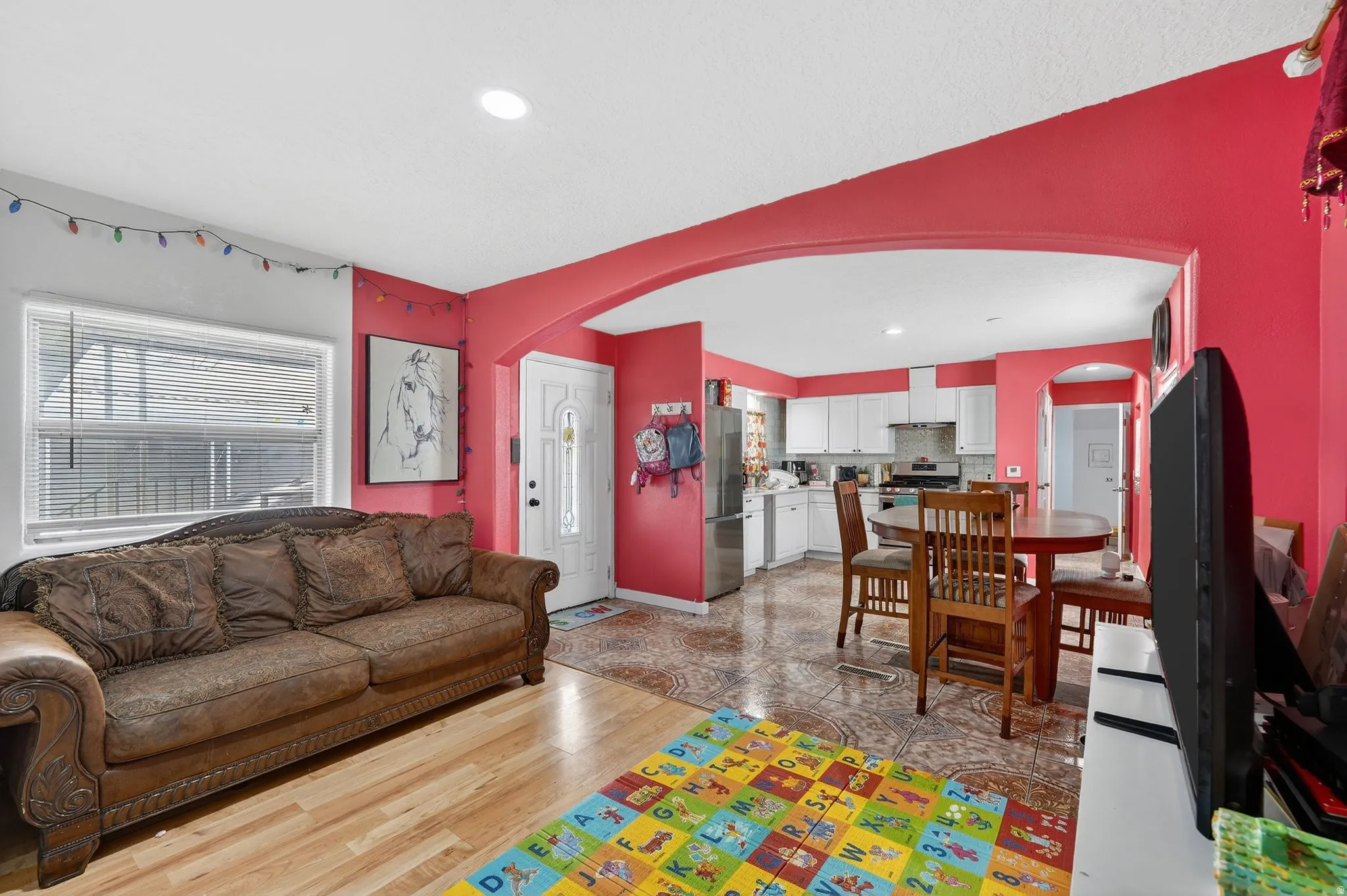 Living room featuring arched walkways, recessed lighting, and light wood-style floors