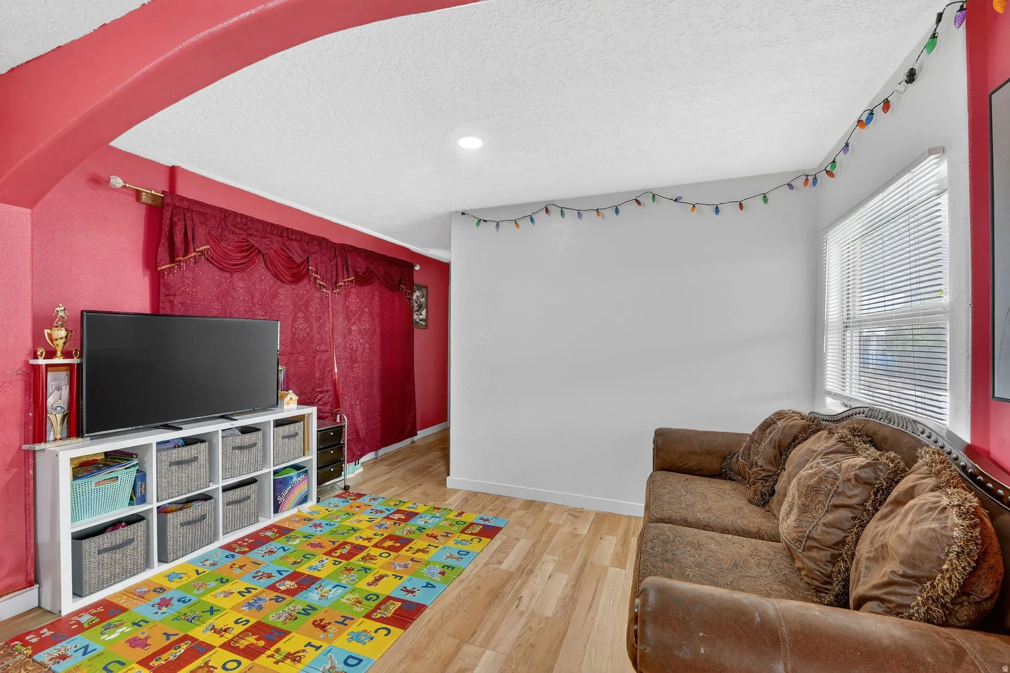 Recreation room with light wood-style flooring, a textured ceiling, and recessed lighting