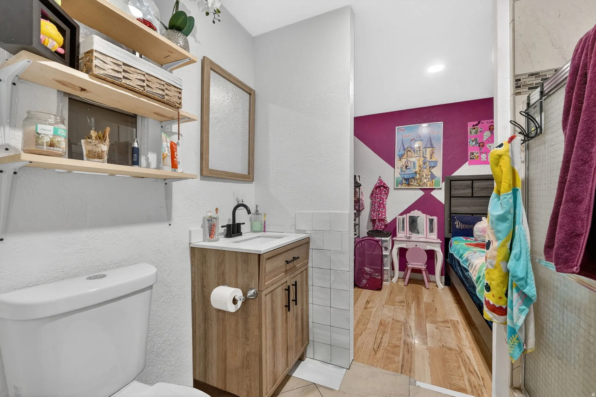 Half bath with a textured wall, vanity, and light wood-type flooring
