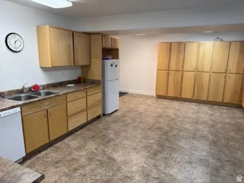 Kitchen featuring white appliances and dark countertops