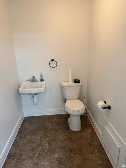 Bathroom featuring toilet and baseboards