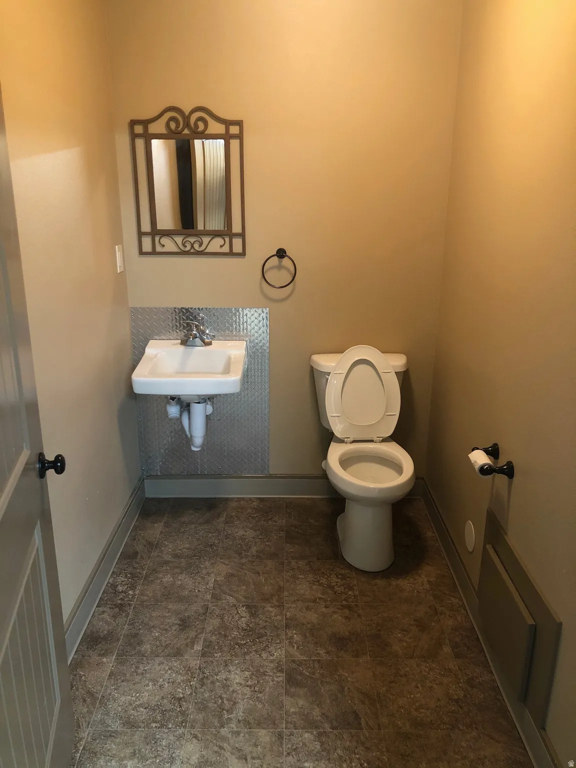 Half bathroom with toilet and baseboards