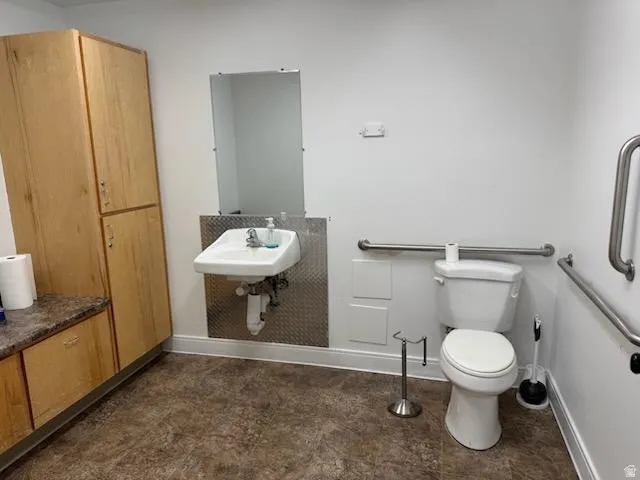 Half bathroom featuring toilet and baseboards