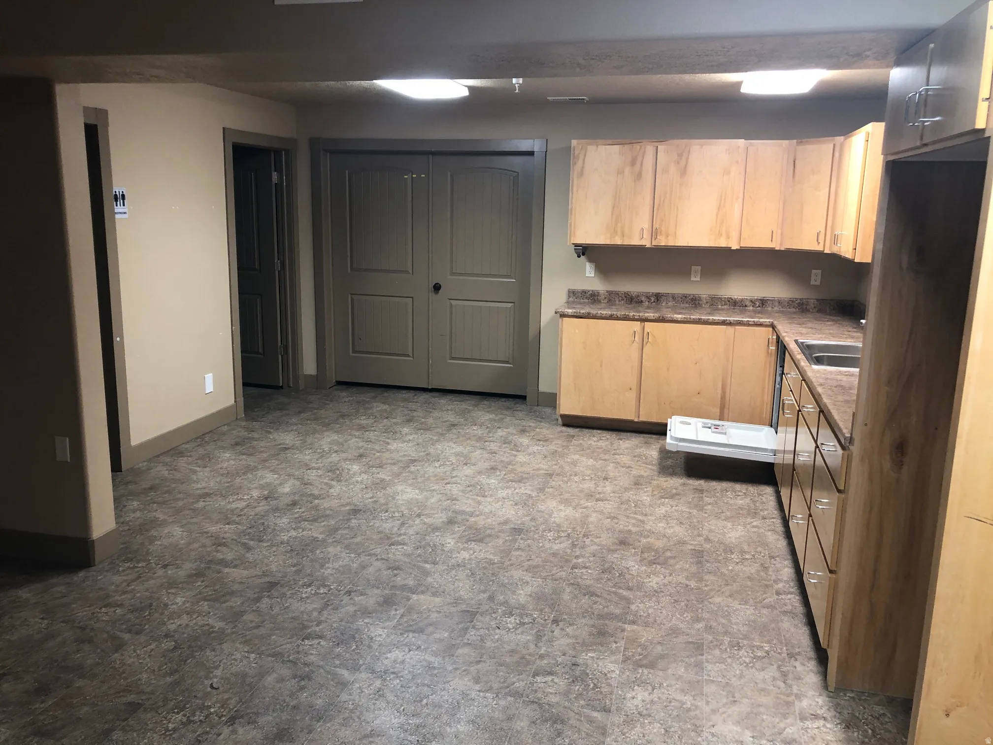 Kitchen featuring dark countertops and light wood finish cabinets