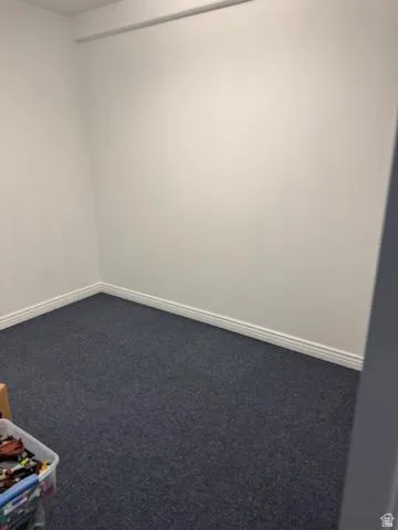 Carpeted spare room with baseboards