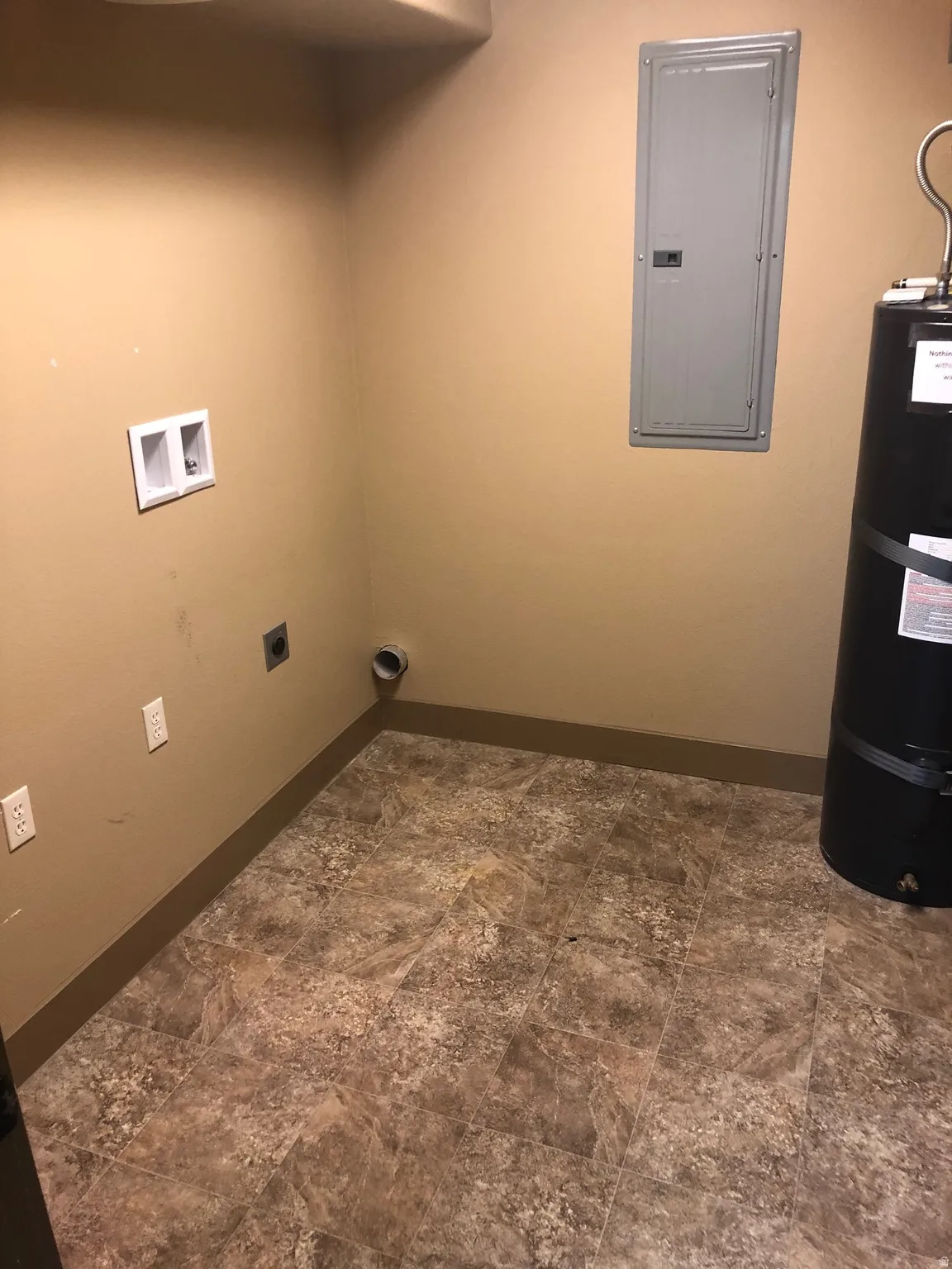 Laundry area with electric panel, hookup for a washing machine, secured water heater, and electric dryer hookup
