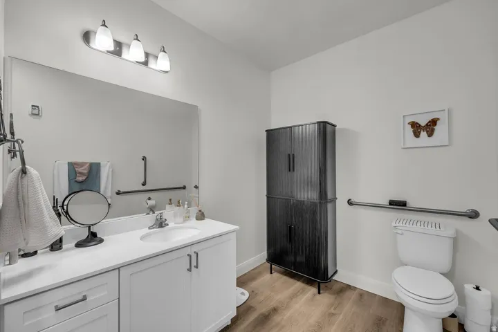 Full bath with vanity and light wood-style flooring