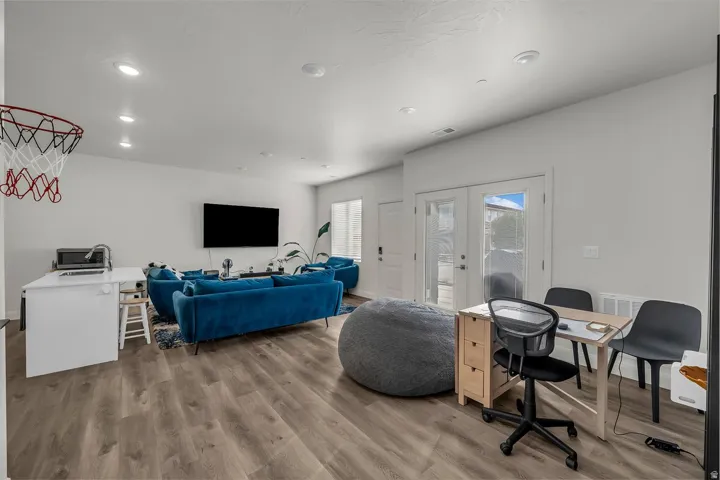 Living room with french doors, light wood-style flooring, recessed lighting, and an office area