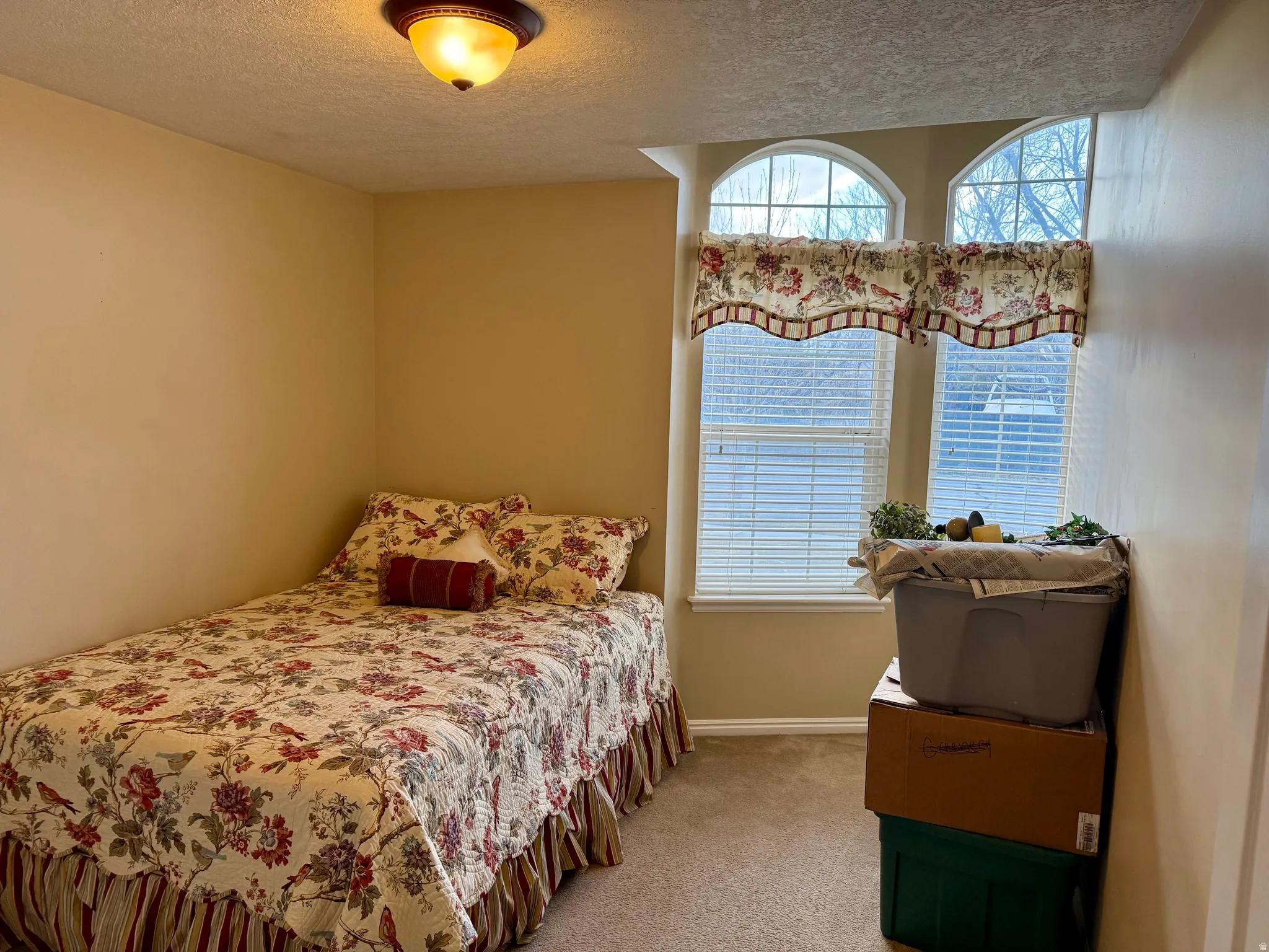 Bedroom with light carpet and a textured ceiling