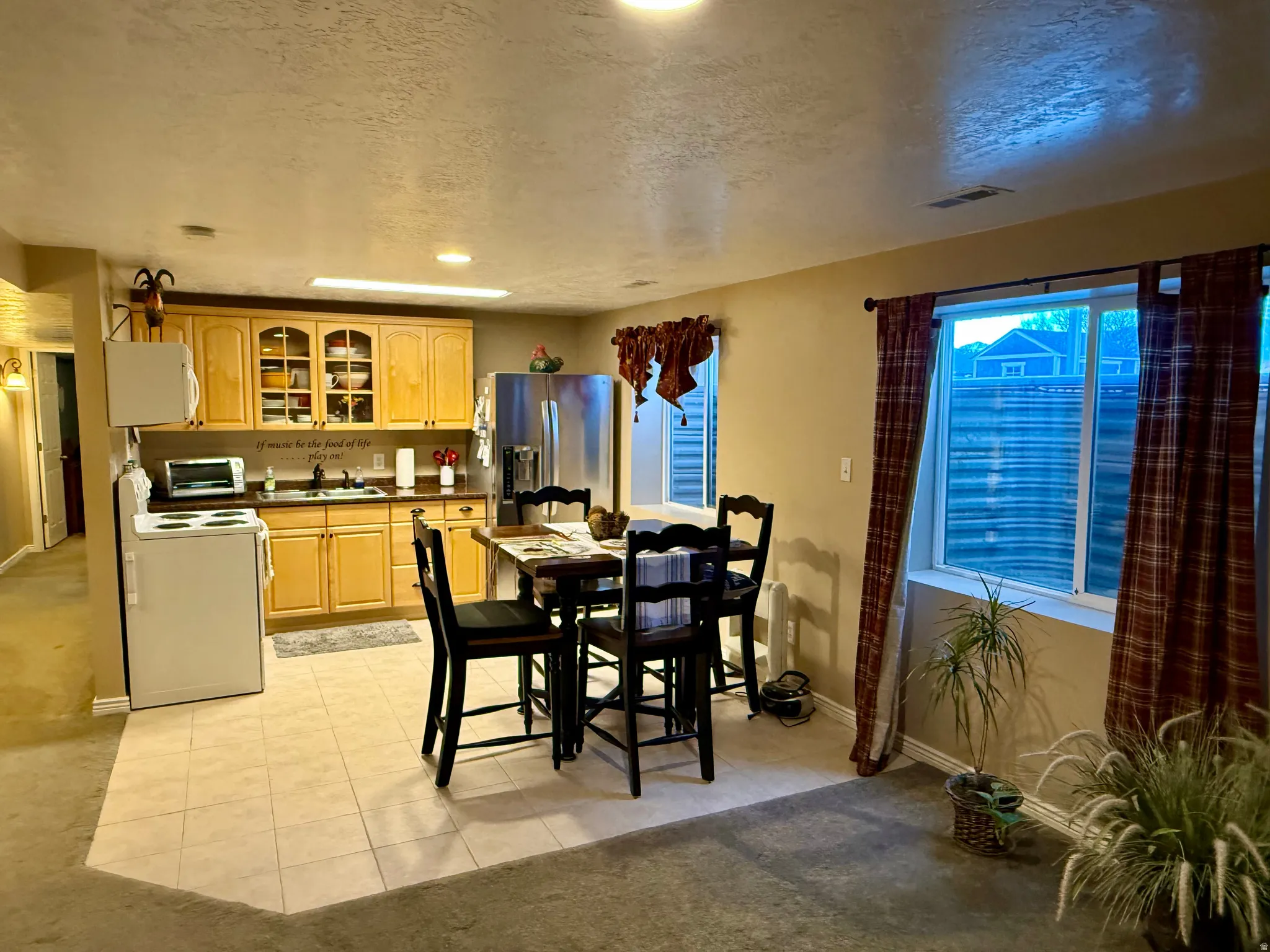 Dining room featuring a textured ceiling, light tile patterned floors, recessed lighting, and light colored carpet