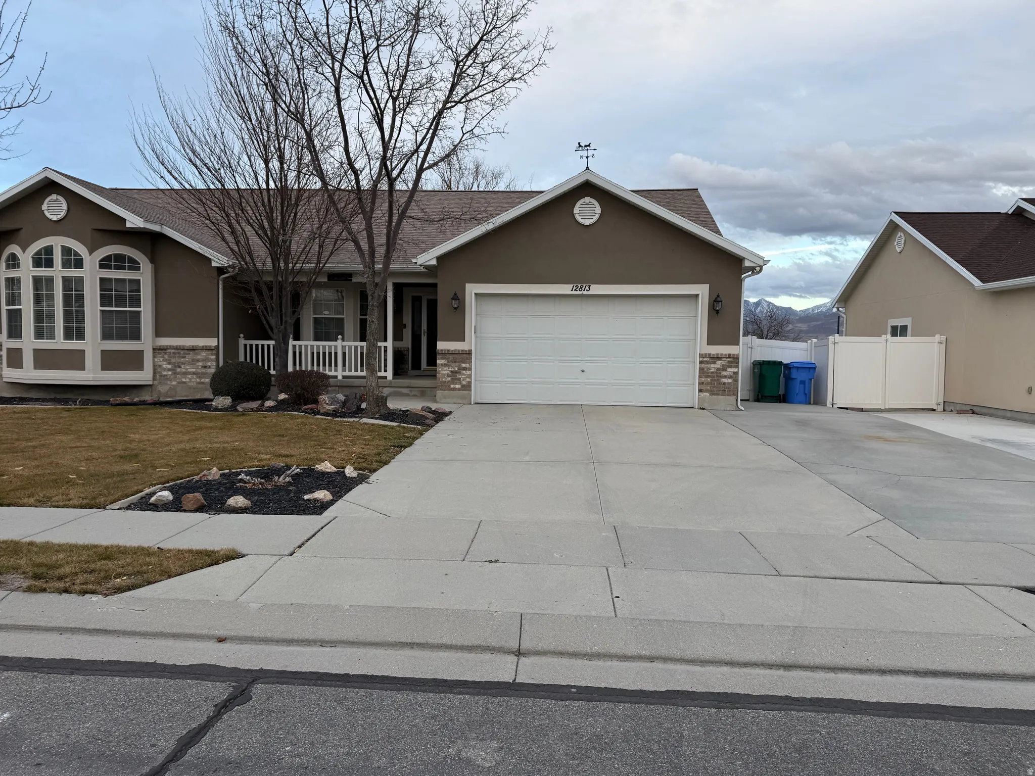 Ranch-style home featuring a porch, concrete driveway, stucco siding, and an attached garage
