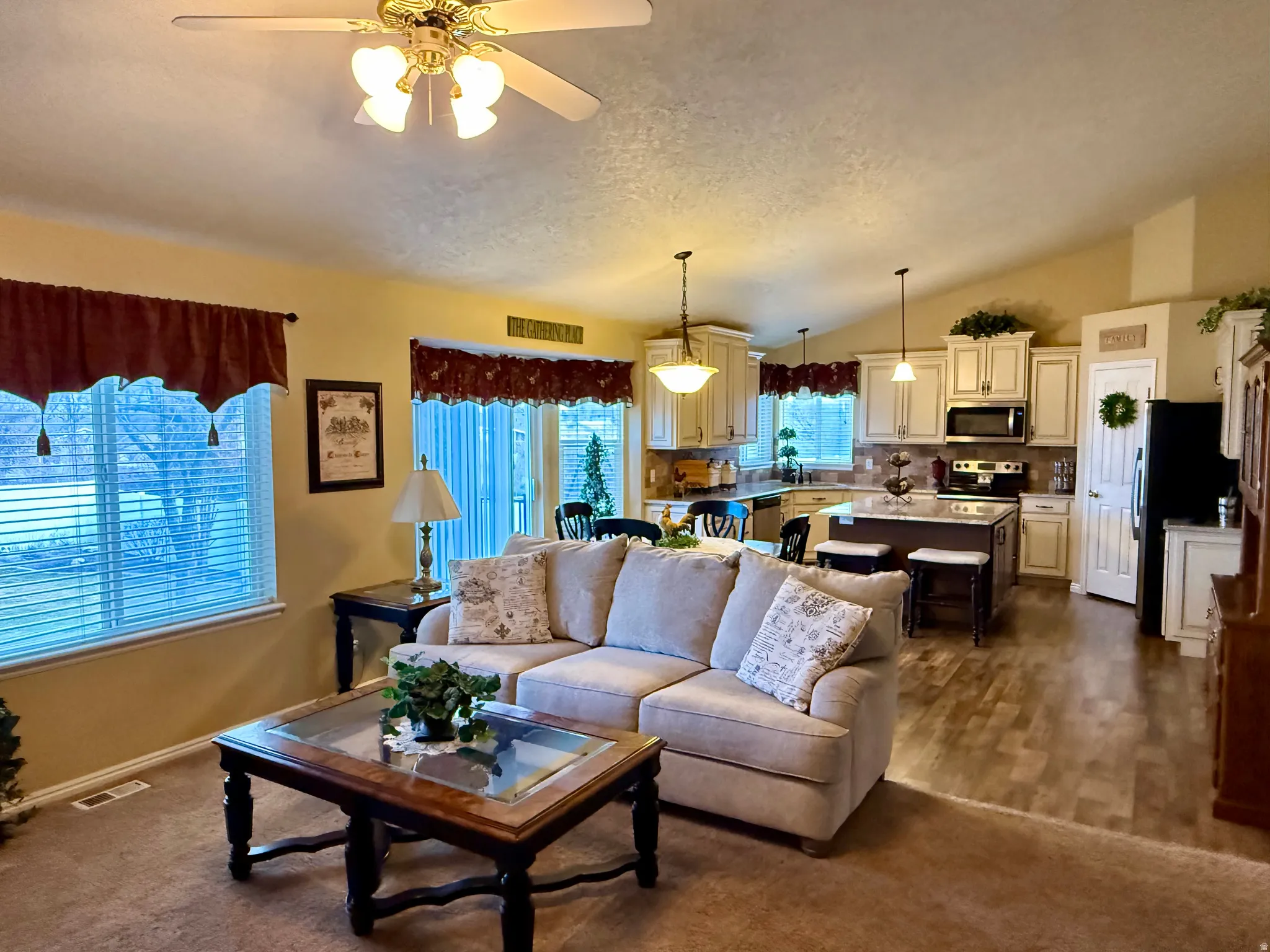 Living room featuring a ceiling fan and dark colored carpet